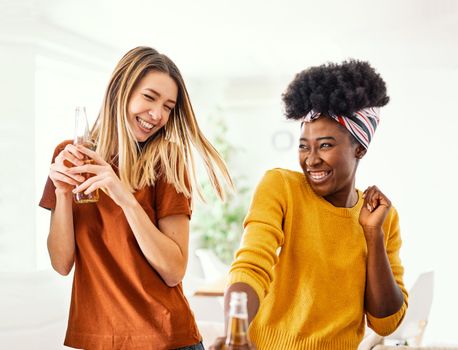 Young african and caucasian woman dancing at a party