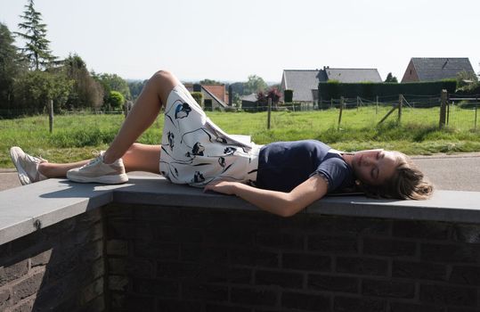 Student girl teenager resting lying on the railing outdoors during. High quality photo