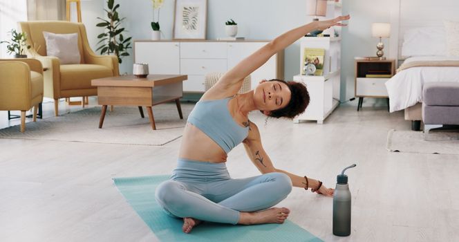 Fitness, yoga or meditation stretching woman for workout in the living room of her house. Girl with chakra focus, mindset or balance while training, exercise or health with zen pilates for wellness