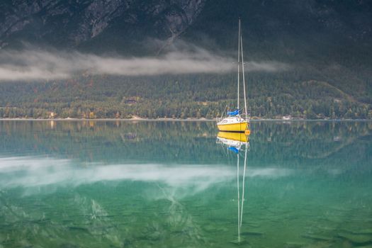 Sailboats on Achensee lake near Innsbruck at peaceful misty dawn, Tyrol alps, Austria