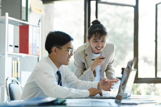 Businesspeople or colleagues are working together on investment project, discussing, sharing ideas, planning, and analyzing the business strategy and finance using laptop computer.