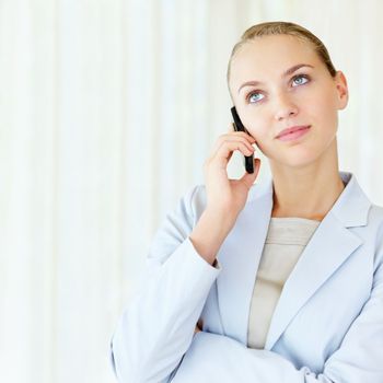 Cute business woman having a conversation over cellphone. Young pretty business woman speaking over the cellphone