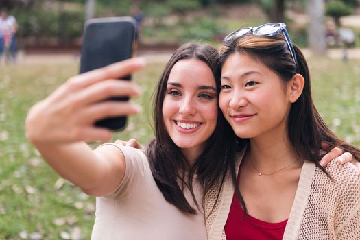 two young friends smiling happy to take a selfie photo with a cell phone, concept of youth and friendship