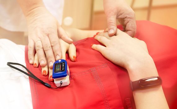Pulse oximeter on the patient's arm. Surgical equipment. Oxygen saturation in the blood.