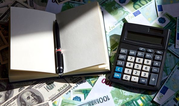 Notepad and pen, dollar and euro on the table. Exchange of dollars and euros.