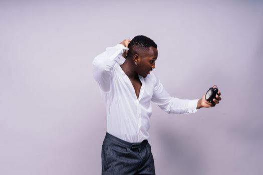 Time Management Concept. Shocked black man holding wall clock, running out of a time.