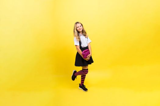 Happy schoolgirl with colored pencils and pencil case in hand