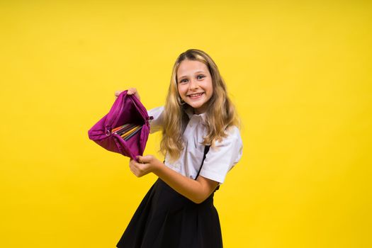 Happy schoolgirl with colored pencils and pencil case in hand