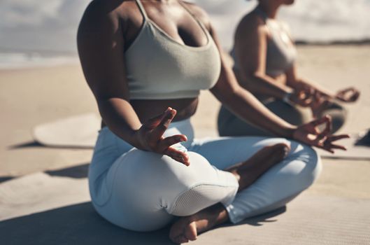 Yoga will allow you to find your Zen moment wherever, whenever. two young women meditating during their yoga routine on the beach