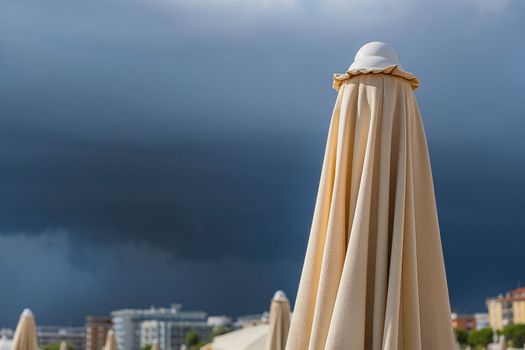 Dramatic dark raining cloud background with umbrella.