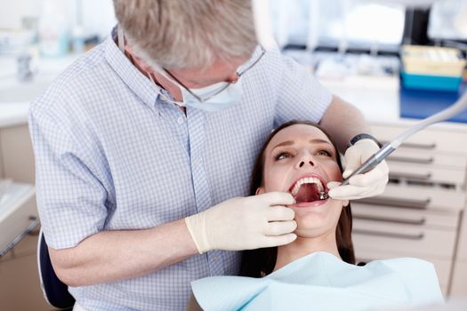 Dentist and patient. Portrait of female patient with dentist at clinic