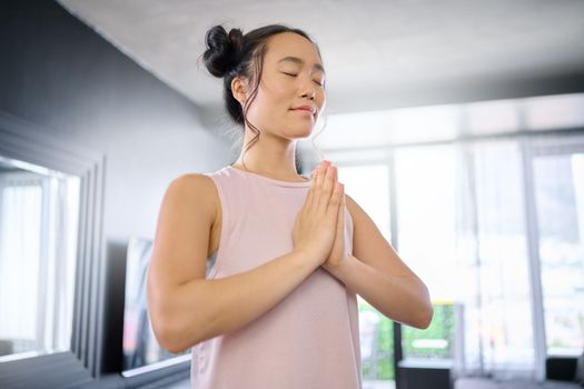 Yoga, meditate and woman with gratitude for her mind, peace and calm start to the morning. Hope, freedom and Asian girl in the living room for a mindset exercise, spiritual faith and mindfulness.