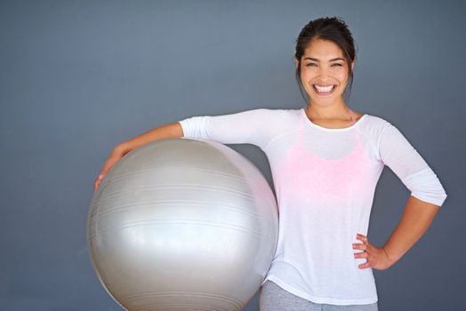 Every day is a good day when I workout. a sporty young woman holding a pilates ball against a grey background