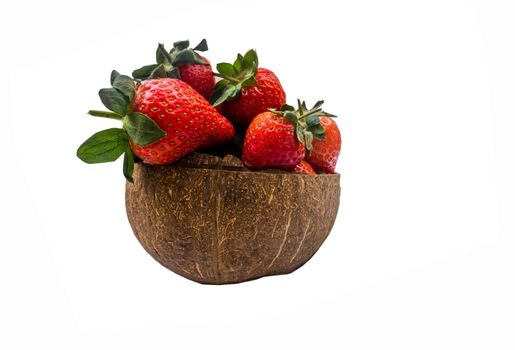 Fresh strawberries in a coconut shell on white background.