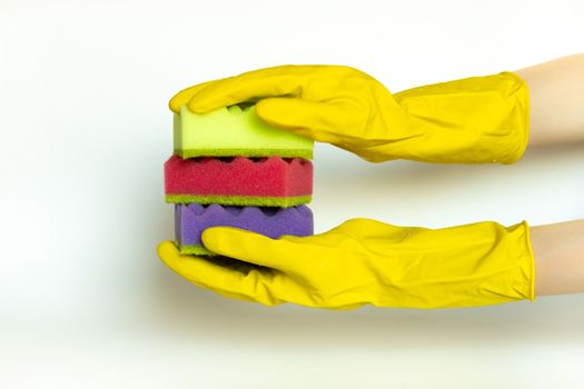 woman hands in protective glove holding stack of vivid multi-colored dish wash sponges . Household cleaning scrub pad. Home cleaning concept.