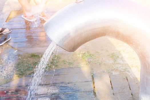 Place for washing the feet on the beach in sunny day. Water jet from a modern big tap.