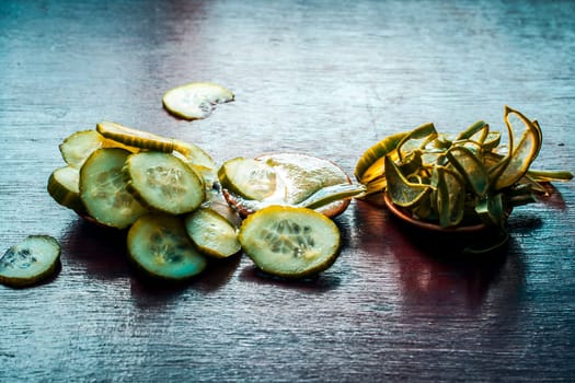 Close-up of ingredients of facial or face pack or face mask on a wooden surface i.e. slices of cucumber and Aloe Vera in dark Gothic colors for brightening and softening the skin.