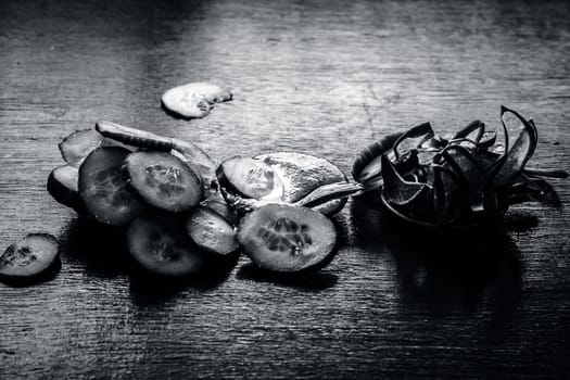 Close-up of ingredients of facial or face pack or face mask on a wooden surface i.e. slices of cucumber and Aloe Vera in dark Gothic colors for brightening and softening the skin.