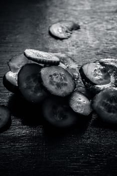 Close-up of ingredients of facial or face pack or face mask on a wooden surface i.e. slices of cucumber and Aloe Vera in dark Gothic colors for brightening and softening the skin.