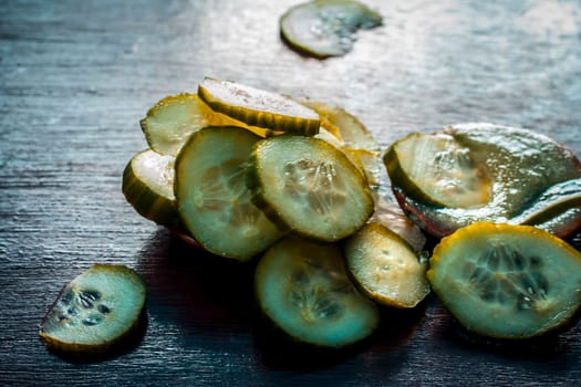 Close-up of ingredients of facial or face pack or face mask on a wooden surface i.e. slices of cucumber and Aloe Vera in dark Gothic colors for brightening and softening the skin.