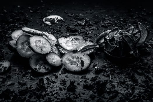 Close-up of ingredients of facial or face pack or face mask on a wooden surface i.e. slices of cucumber and Aloe Vera in dark Gothic colors for brightening and softening the skin.