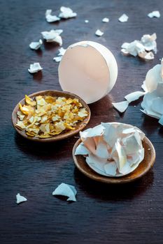 Close up of face pack consisting of egg peel and honey on a wooden surface in dark Gothic colors for soft and smoother skin.