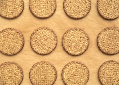 Freshly baked homemade sesame seed cookies on wooden board, rustic table. Healthy, tasty snack, honey seed bar, round form biscuits. Organic dessert, top view in row vegan