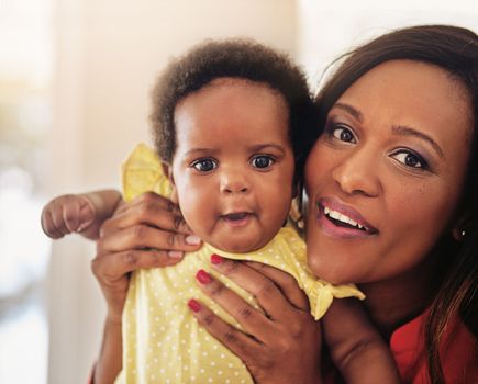 Cuteness runs in the family. Portrait of a mother holding up her baby girl