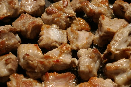 Close up Pork bone fried in a cooking pan with garlic