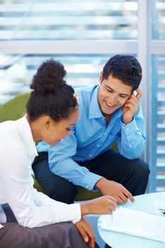 Business people conversing about document. Portrait of mixed race business people conversing about document at office