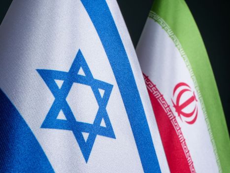 Flags of Israel and Iran, as conflict between countries.