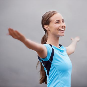 Embracing positivity. a young woman training outdoors with her arms outstretched