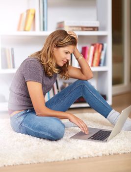 Enjoying the freedom of wireless technology at home. a young woman using her laptop at home