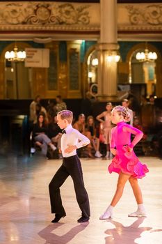 Attractive young couple of children dancing ballroom dance. Girl and boy dancer Latino international dancing.