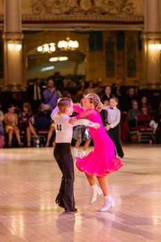 Attractive young couple of children dancing ballroom dance. Girl and boy dancer Latino international dancing.