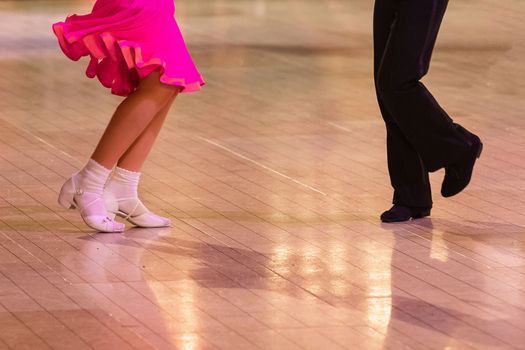 Attractive young couple of children dancing ballroom dance. Girl and boy dancer Latino international dancing.