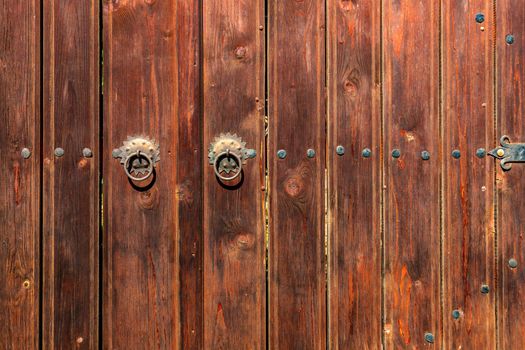 Old vintage wooden door ornate with a beauty metal furniture. Close up