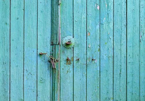 Old turquoise painted wood gate. Closed door background 
