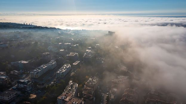 Fog clouds over the city from the sea, view from above