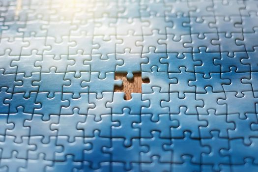 The missing piece of the sky puzzle, the concept of completing a big job, the final of the project, the successful solution of business problems. The hand puts the last piece of the jigsaw