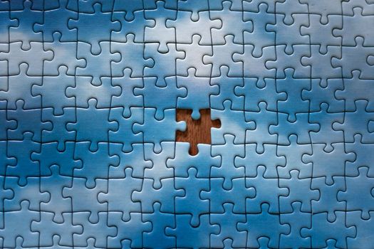 The missing piece of the sky puzzle, the concept of completing a big job, the final of the project, the successful solution of business problems. The hand puts the last piece of the jigsaw