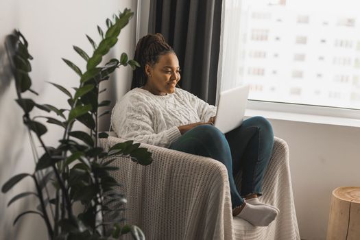 African american young woman using laptop on bed - technologies and communication and social network