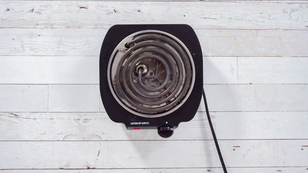 Flat lay. Portable one burner electric stove on the table.