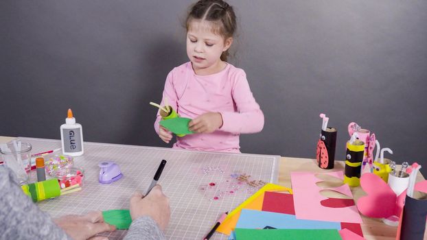 Kids papercraft. Making paper bugs out of the empty toilet paper rolls and construction paper.