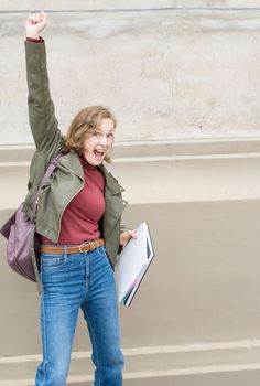 young student girl jumps and gesticulates expressing joy about passing the exam, bright emotions, High quality photo