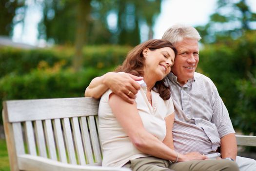 What a lovely day. a couple on a bench outdoors