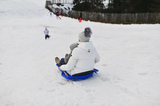 The mother with child sledding in the snow