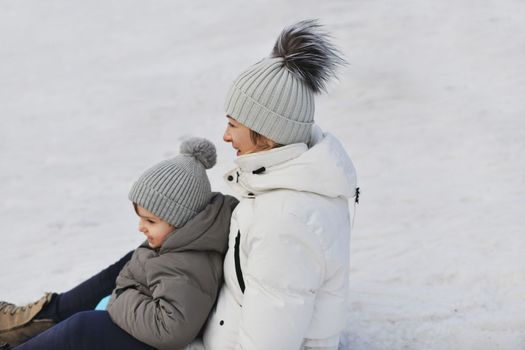 The mother with child sledding in the snow