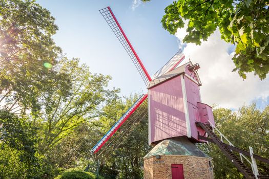 Rustic and iconic wooden windmill in idyllic Bruges public park, Belgium