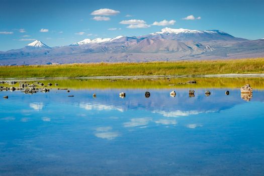 Mountains and Peaceful reflection lake with dramatic volcanic landscape at Sunset, Atacama Desert, Chile